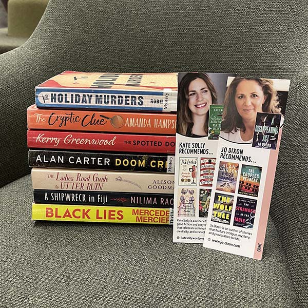 A book stack on an armchair, showing Crime novels that are part of the Crime and Cozy Crime recommended reading list